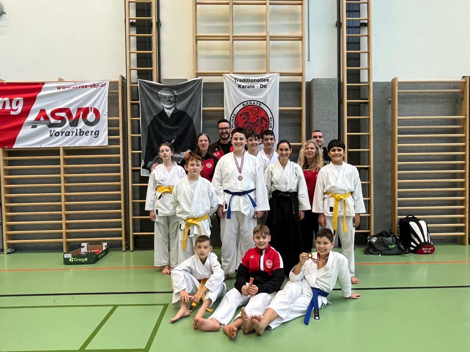 Gruppenfoto mit den teilnehmenden Karatekas aus Bludenz im Gi nach dem Turnier in der Halle.
