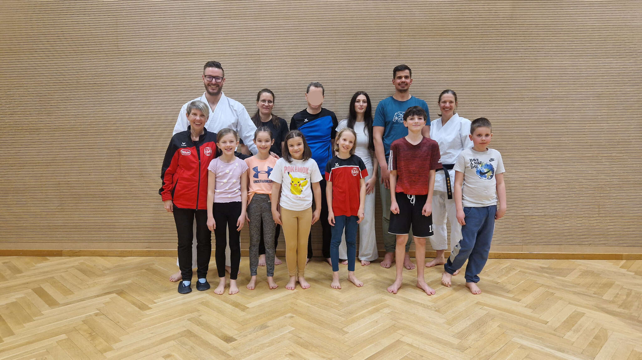 Gruppenfotos mit den 10 Prüflingen und den drei Trainer*innen in der Halle nach den erfolgreichen Gürtelprüfungen