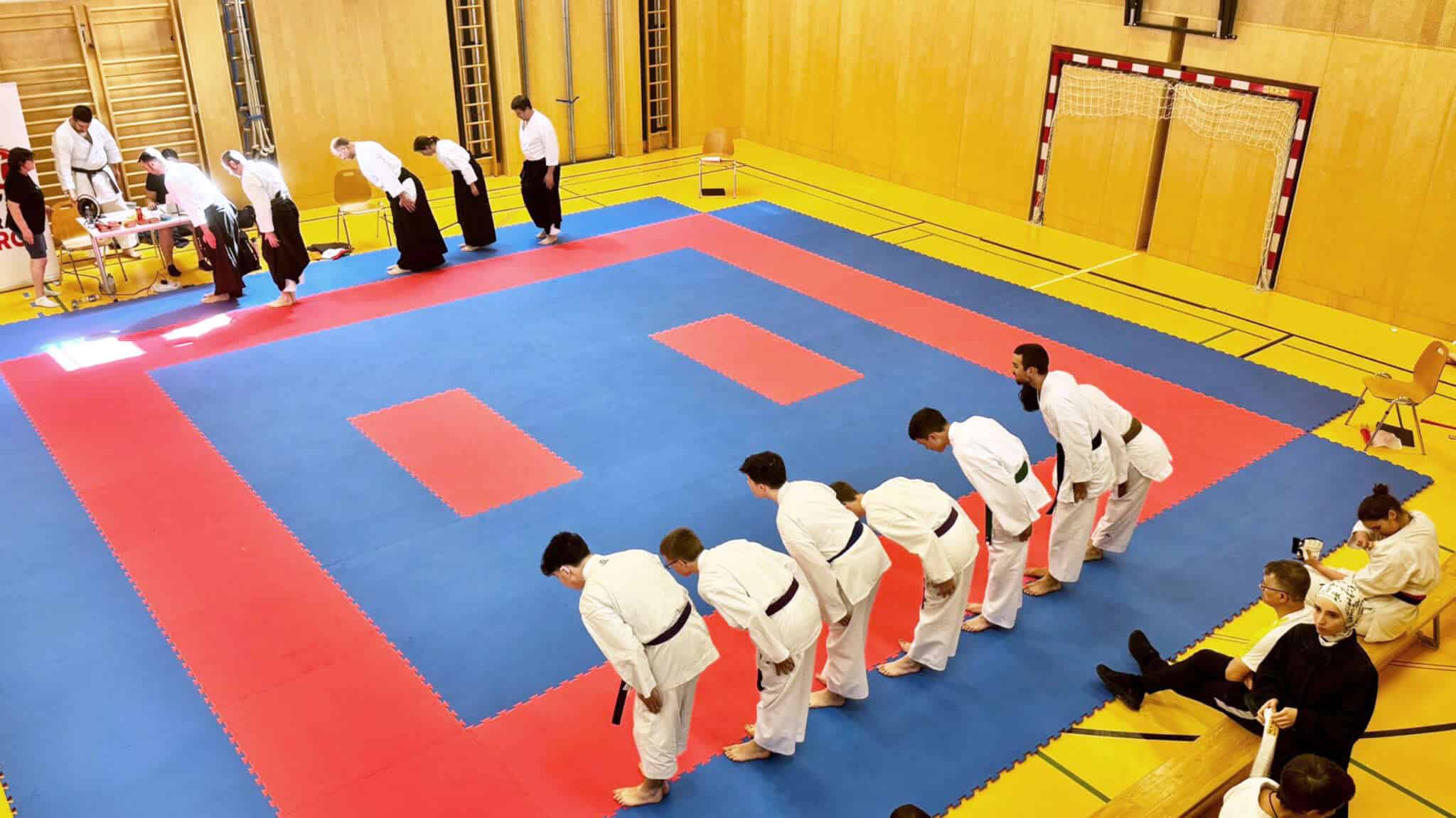 Die Wettkampfteilnehmer und Schiedsrichter verbeugen sich auf dem Tatami