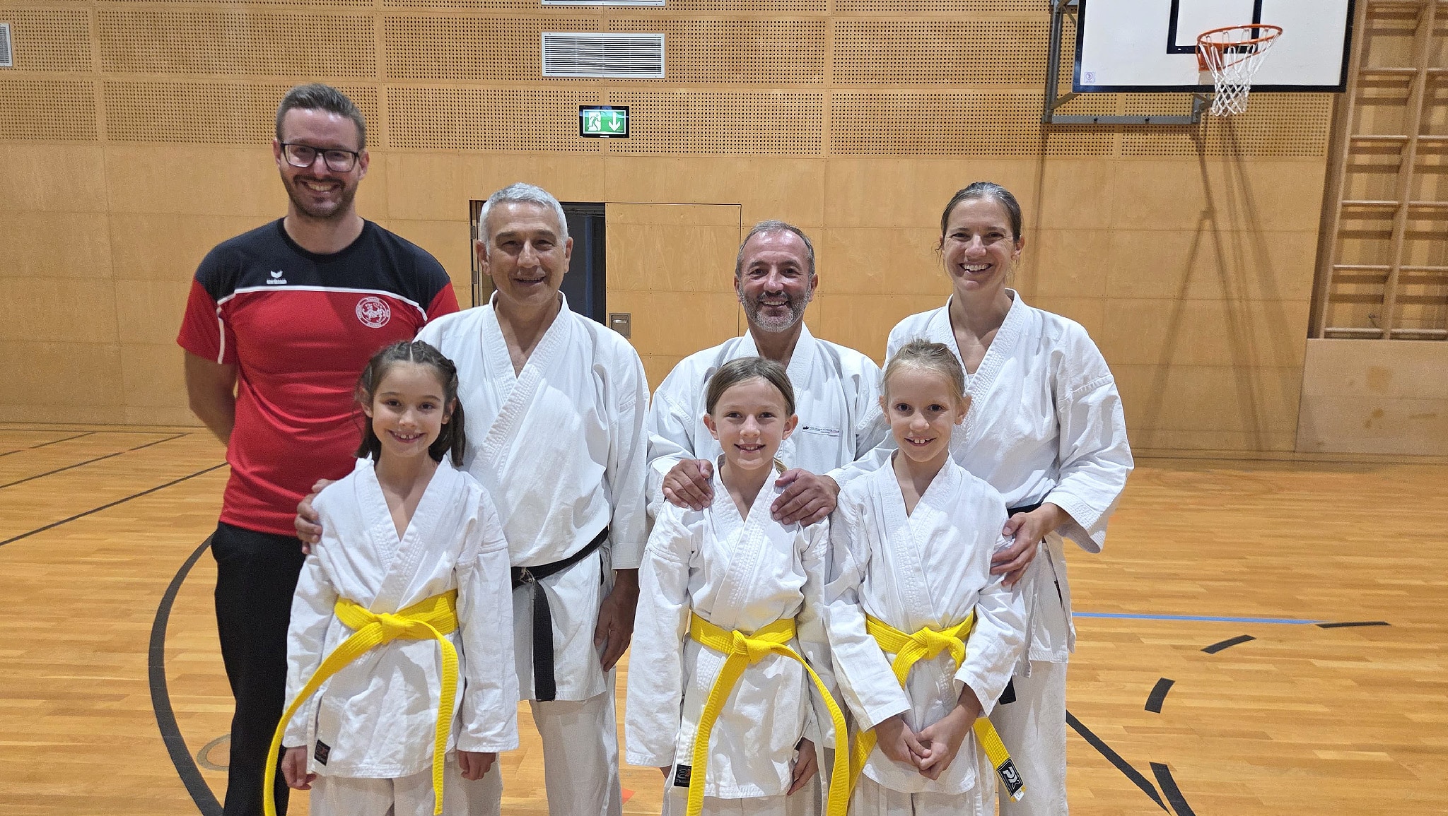 Gruppenfoto mit Sensei Cardinale, Sensei Campari und den 5 Bludenzer Teilnehmer*innen im Gi in der Halle nach dem Training