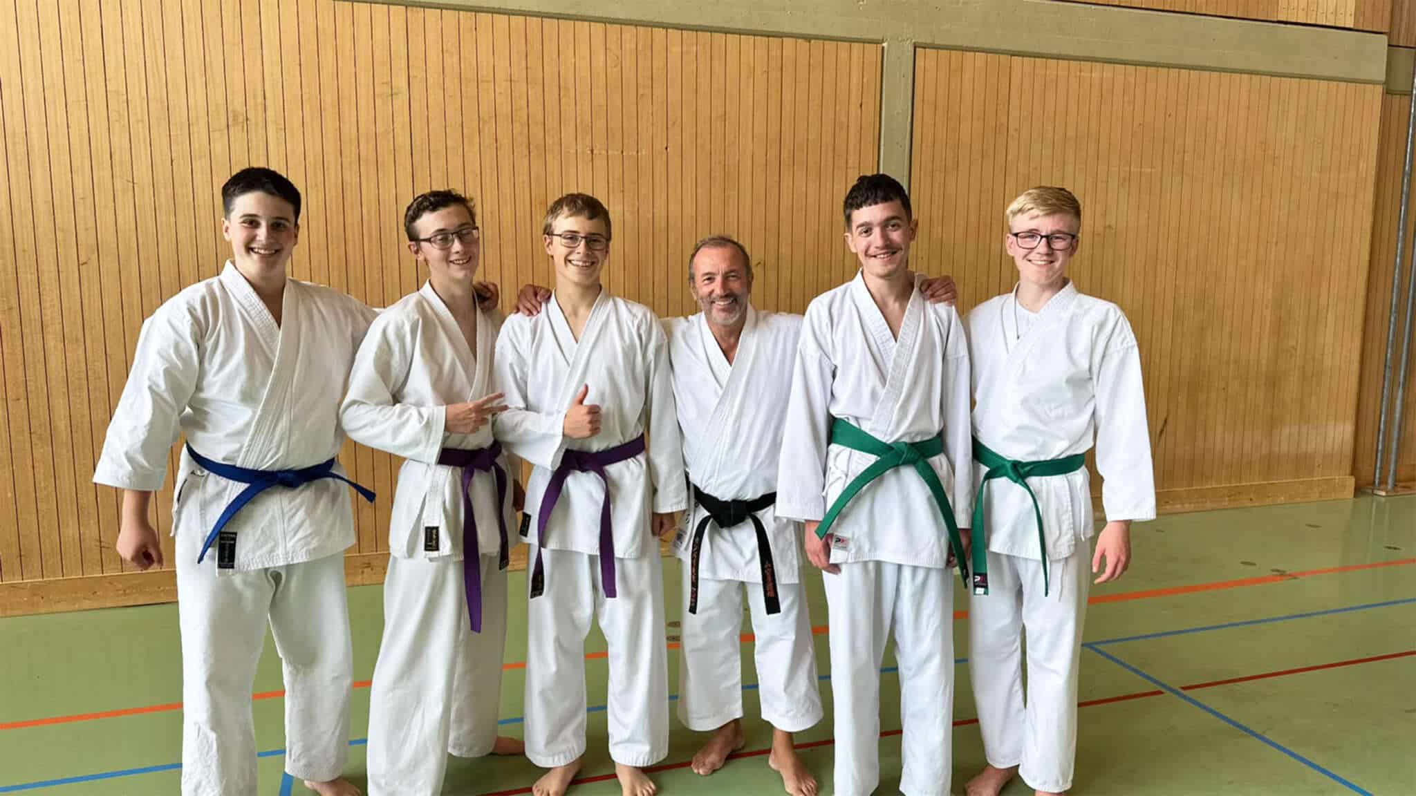 Gruppenfoto mit Sensei Campari und den 5 teilnehmenden Karatekas aus Bludenz im Gi in der Halle nach dem Training.